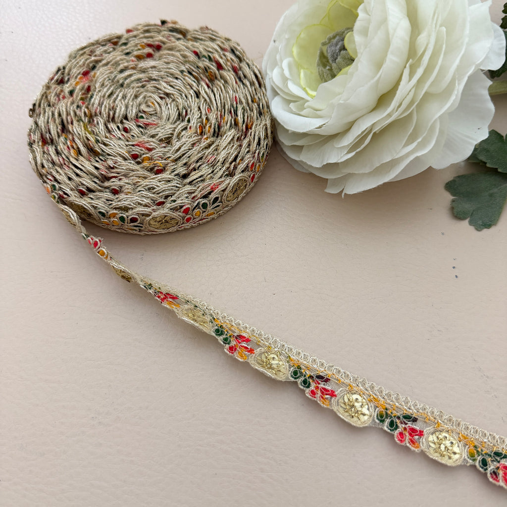 Decorative ribbon with floral pattern on a white surface with a white flower.