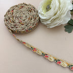 Decorative ribbon with floral pattern on a white surface with a white flower.