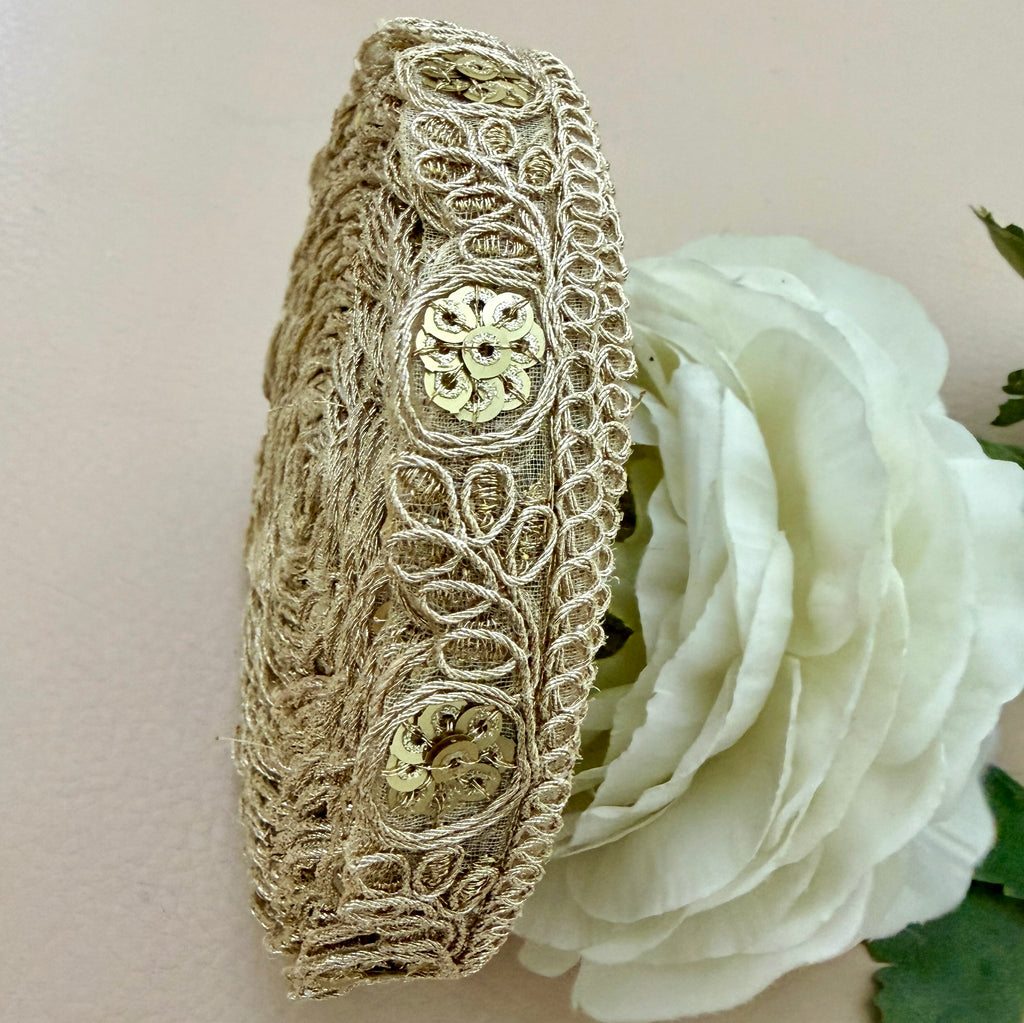 Decorative headband with intricate lace design on a white rose background