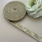 Roll of decorative ribbon with a white flower on a light background