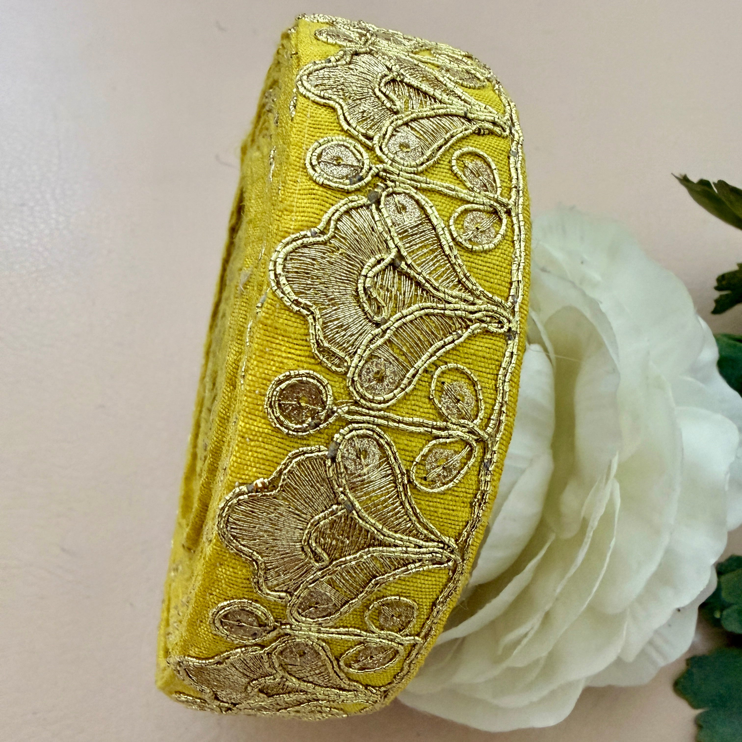 Decorative yellow ribbon with intricate gold patterns on a white flower background