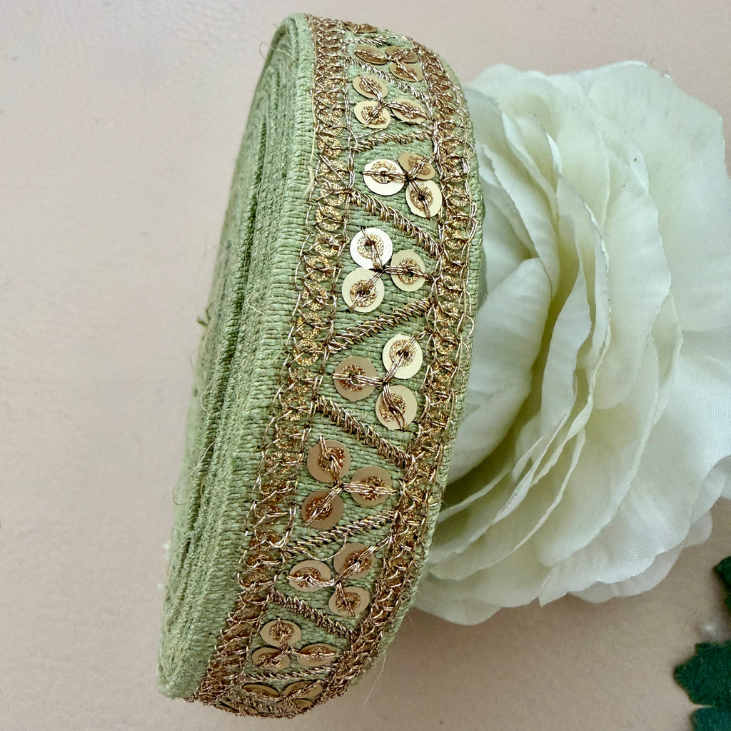 Green headband with gold sequin detailing on a white flower background