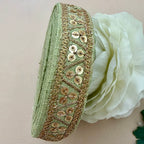 Green headband with gold sequin detailing on a white flower background