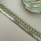 Decorative silver lace trim on a light background with a white flower.