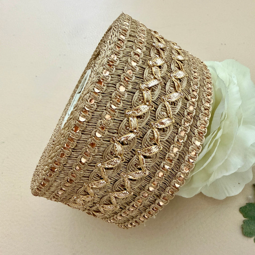 Decorative gold headband with intricate patterns on a light background