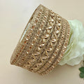 Decorative gold headband with intricate patterns on a light background