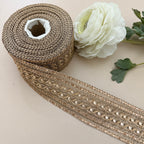 Roll of decorative ribbon with a white flower on a light background