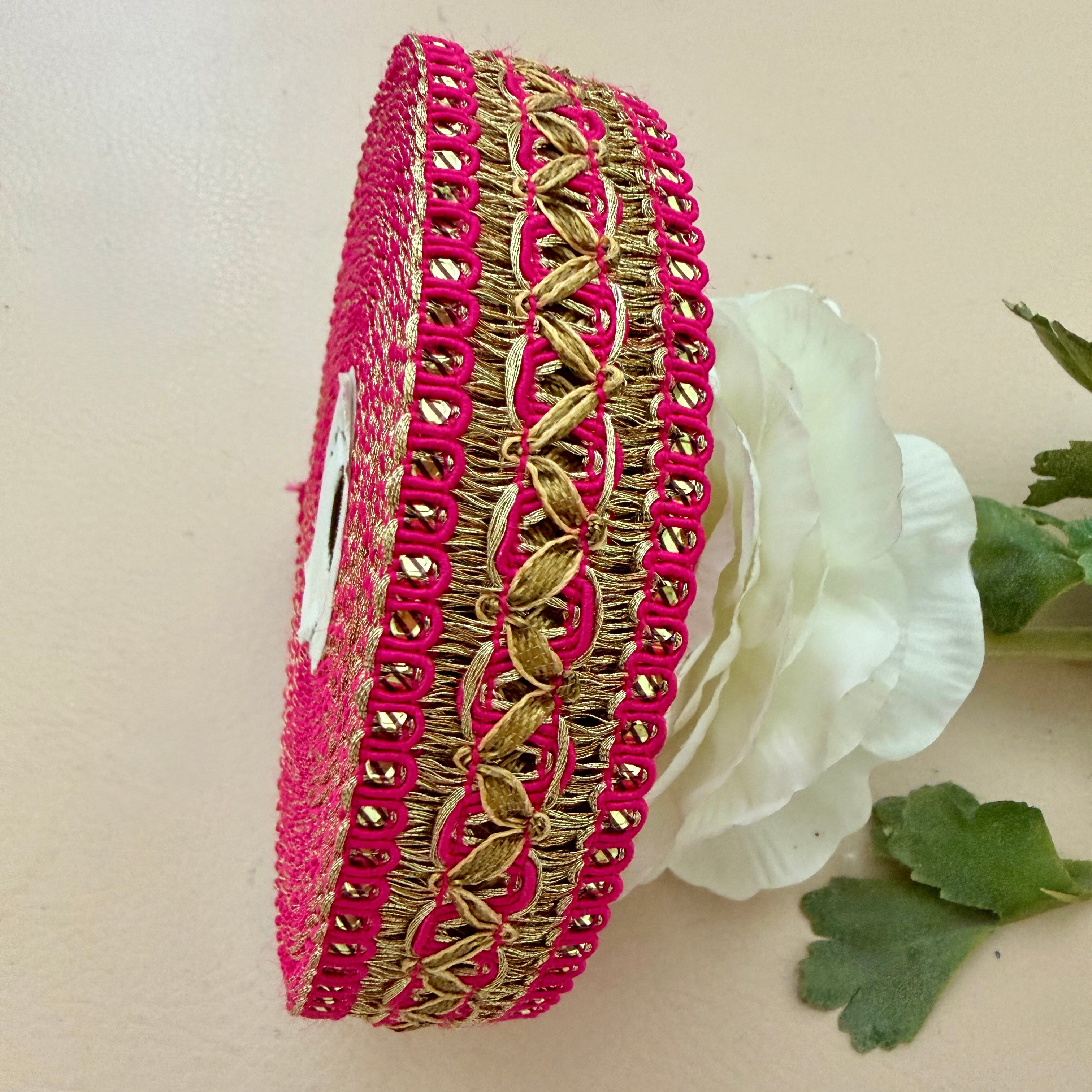 Two pink and gold bangles with a white flower in the background