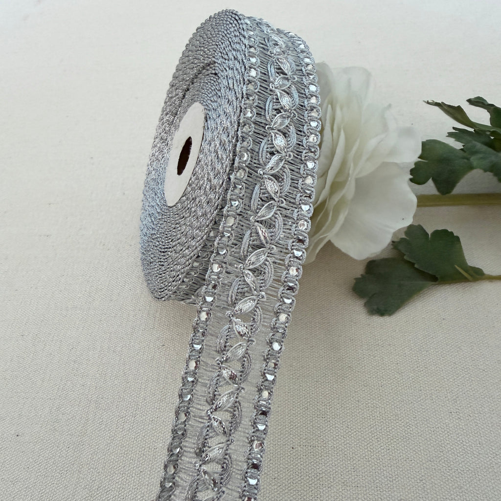 Decorative silver ribbon with crystals on a beige background