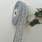 Decorative silver ribbon with crystals on a beige background