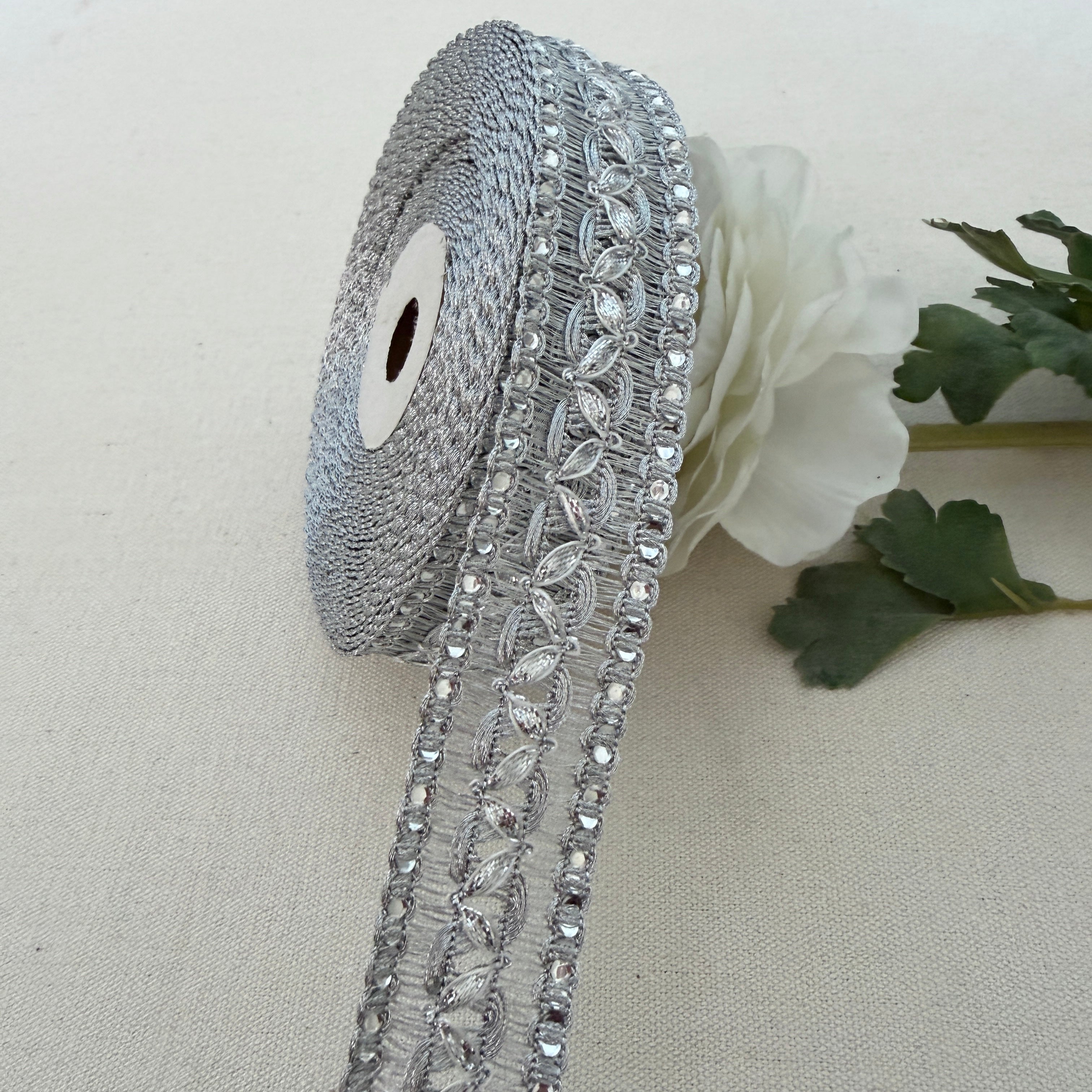 Decorative silver ribbon with crystals on a beige background