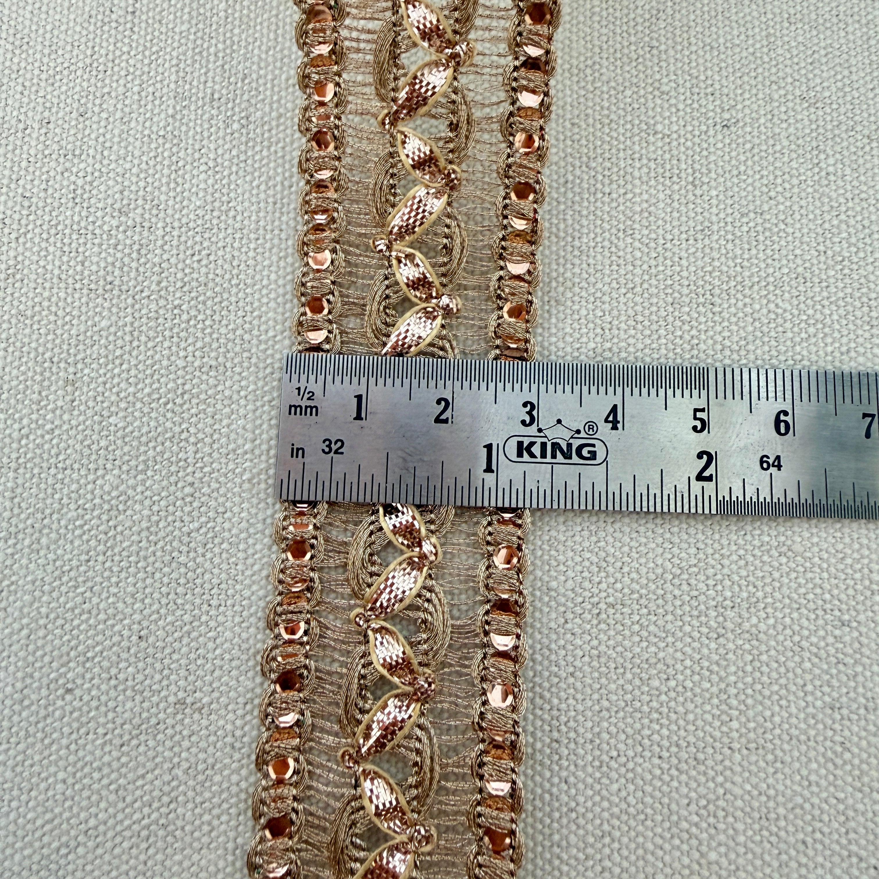 Decorative lace trim with a ruler for measurement on a neutral background