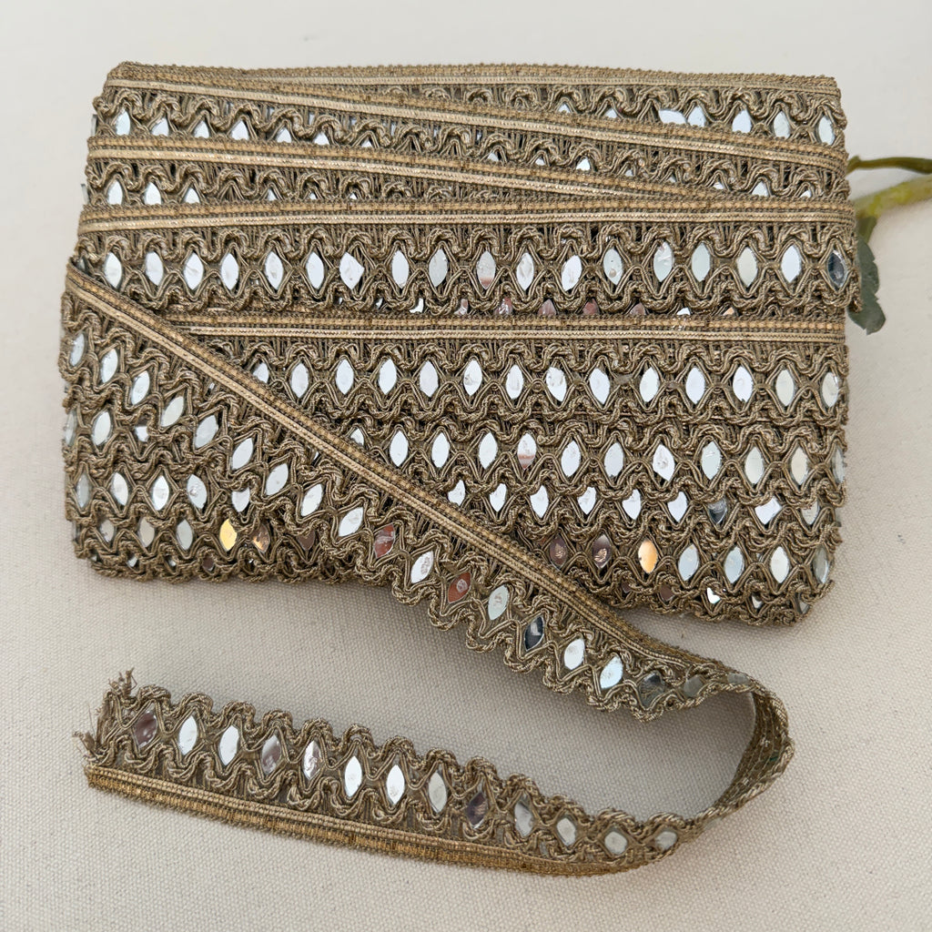 Decorative lace trim with intricate patterns on a beige background