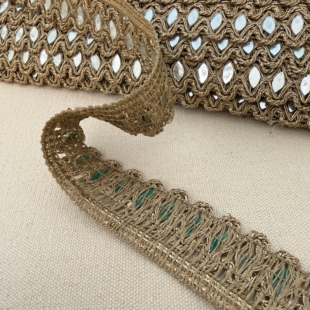 Close-up of decorative lace trim on a beige fabric background