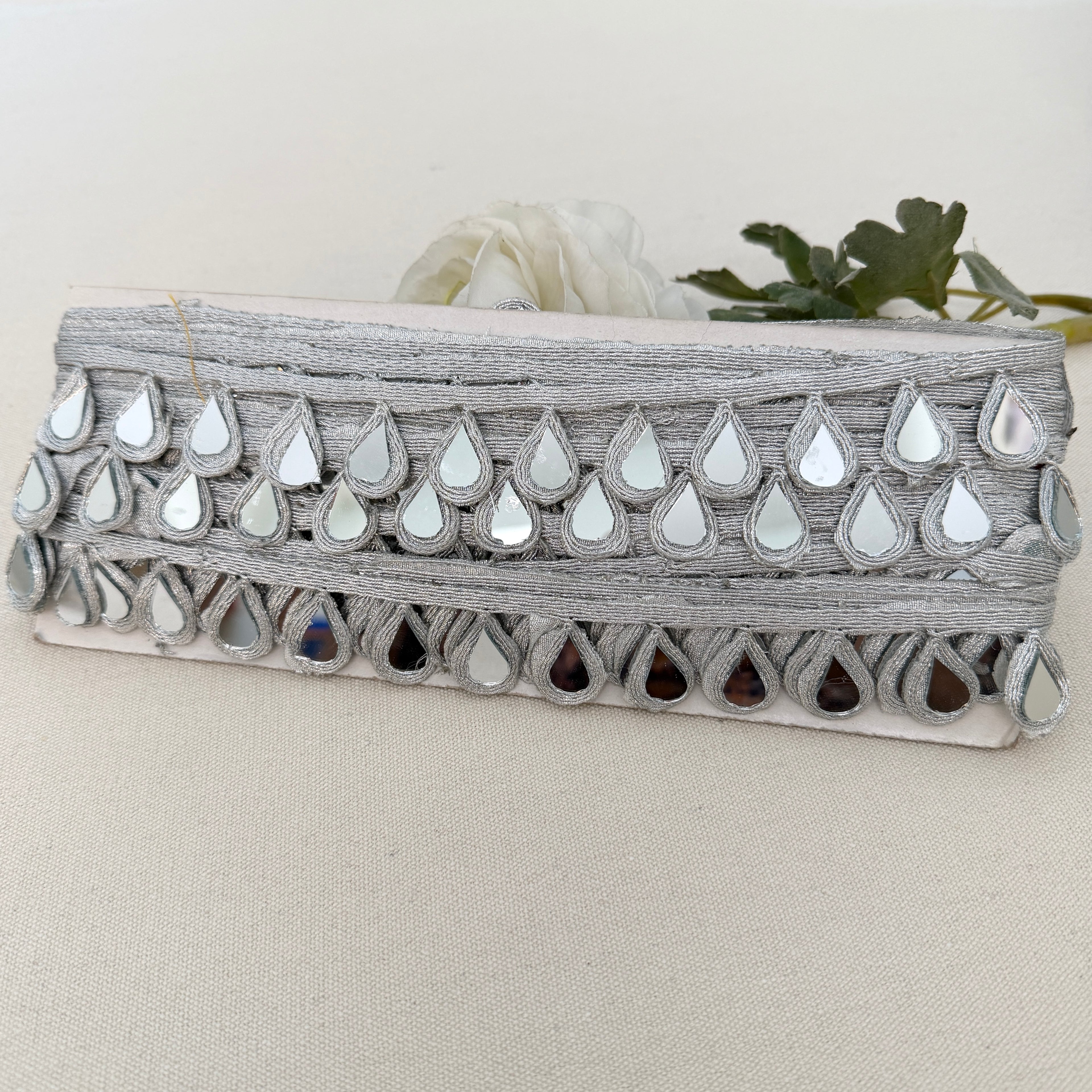 Decorative planter with reflective teardrop designs on a neutral background