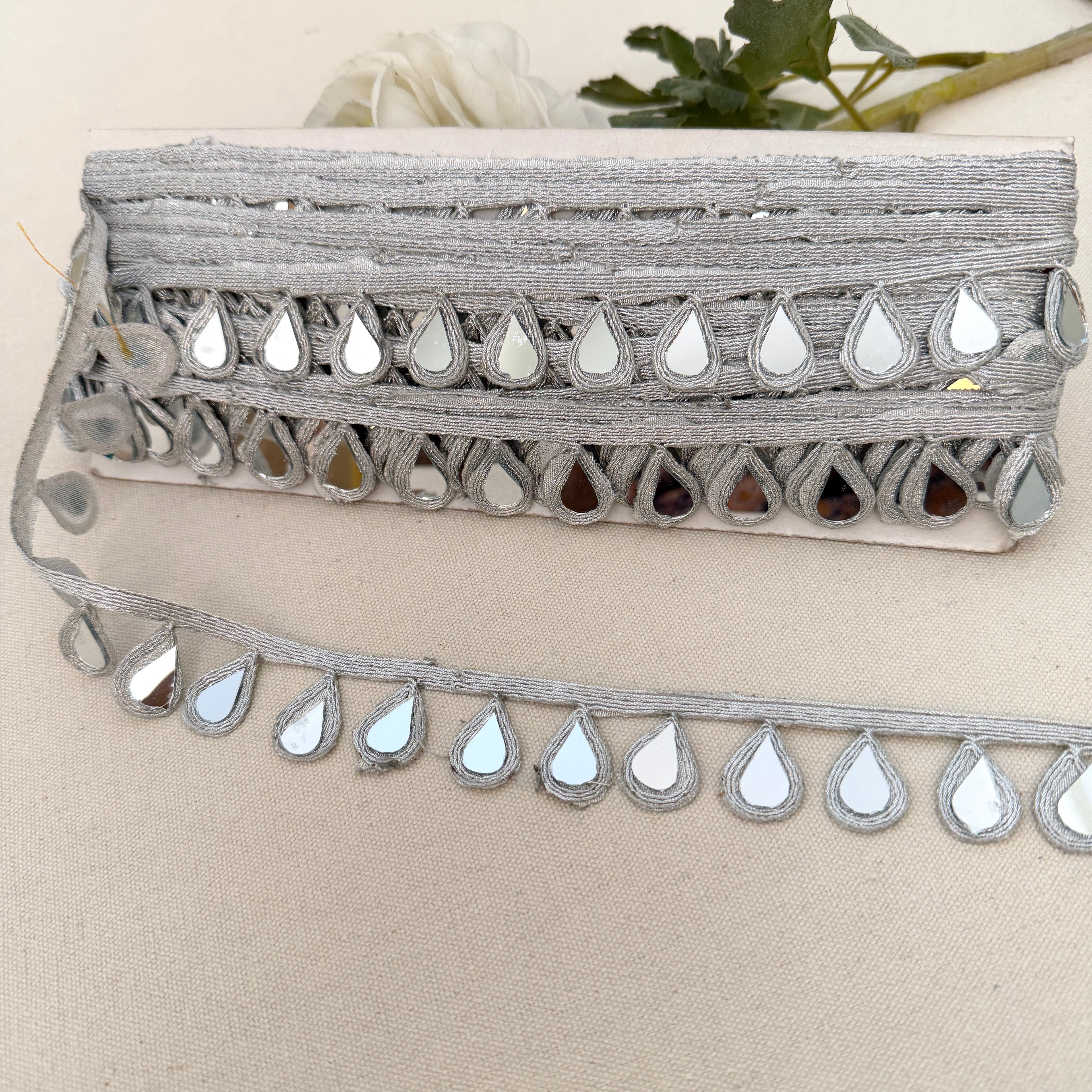 Decorative trim with mirror-like stones on a beige background