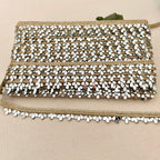 Beaded clutch bag with gold and white accents on a beige background