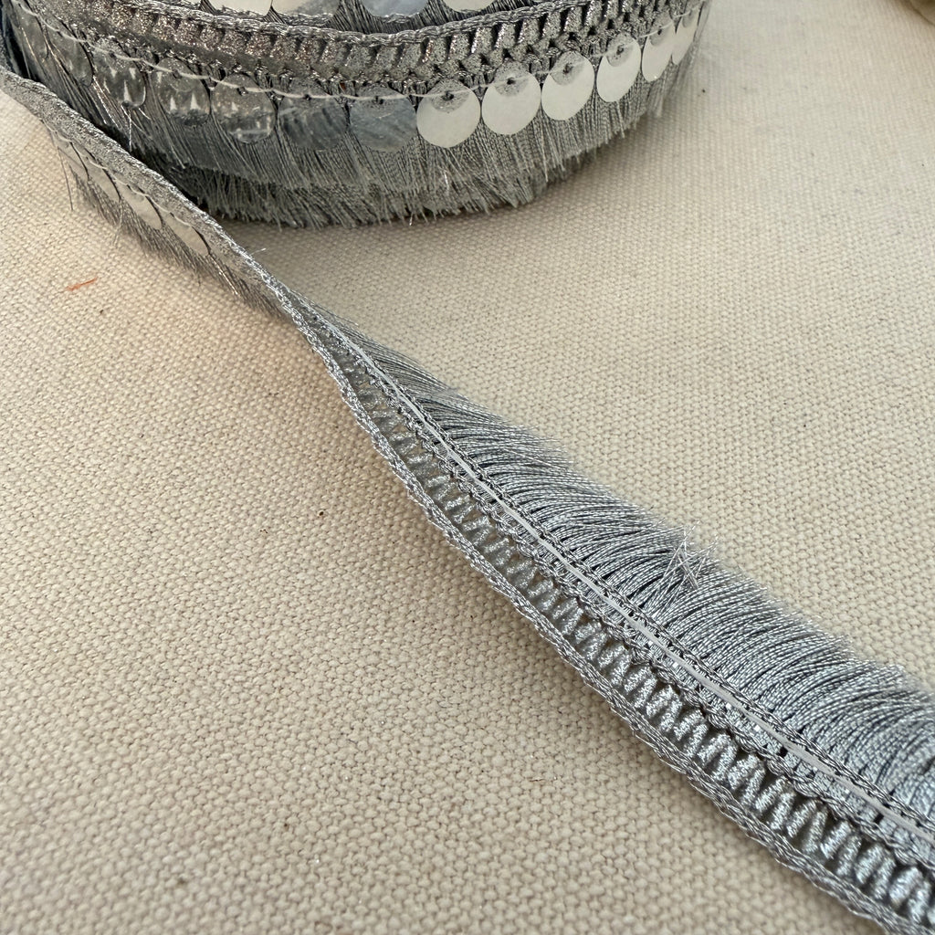 Close-up of a textured gray ribbon on a beige fabric background