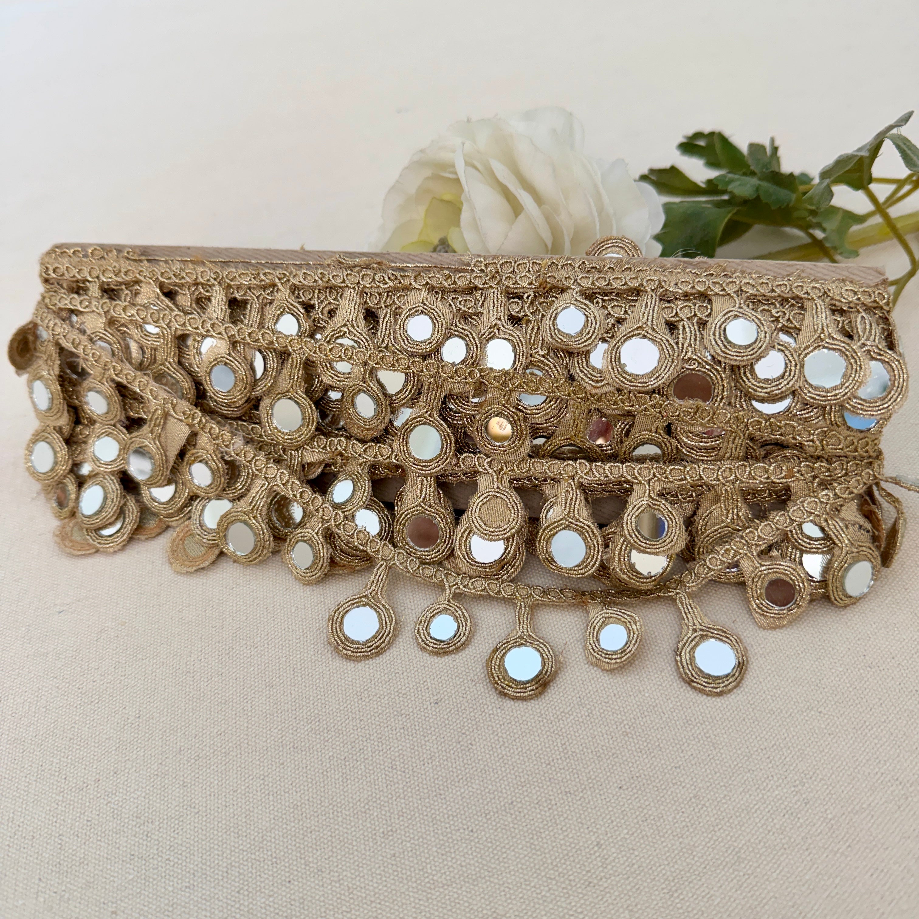 Decorative belt with mirror embellishments on a neutral background
