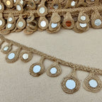 Decorative gold trim with mirror embellishments on a beige fabric background