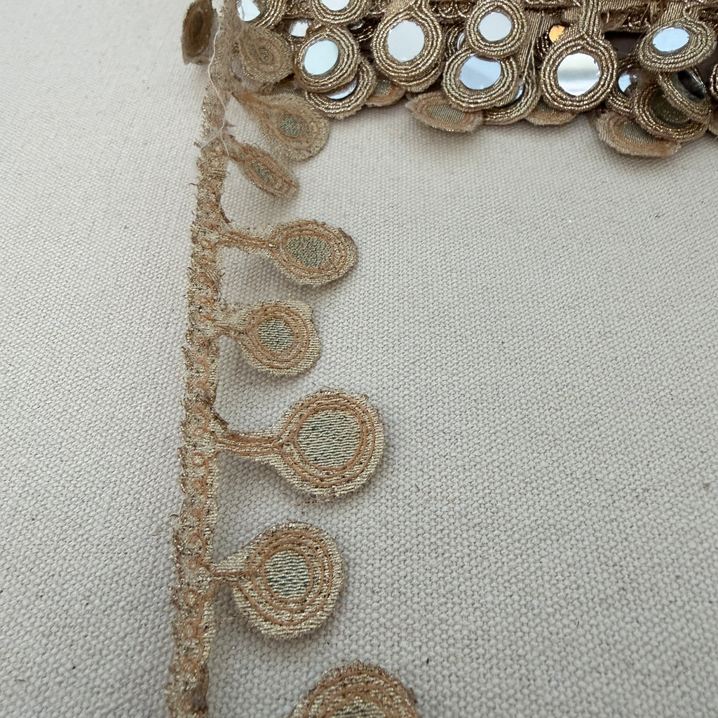 Close-up of decorative fabric with intricate patterns on a beige background