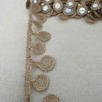 Close-up of decorative fabric with intricate patterns on a beige background