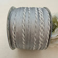 Spool of gray yarn on a beige background