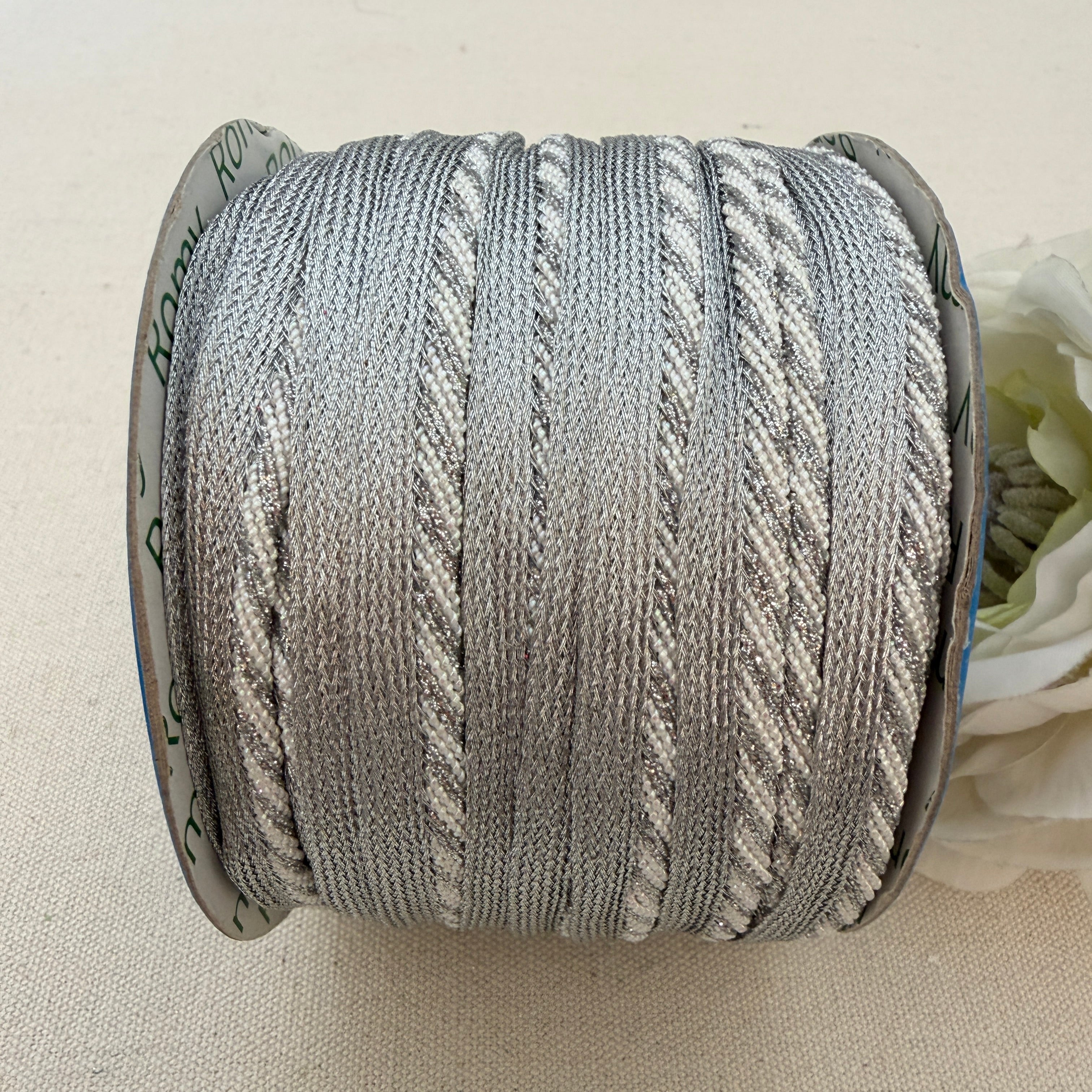 Spool of gray yarn on a beige background