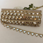 Gold lace trim with mirror-like triangles on a beige background
