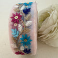 Decorative ribbon with floral embroidery on a light background