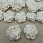White crocheted flowers on a beige fabric background