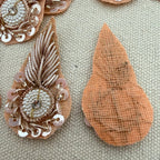 Decorative brooch with intricate design on a textured surface