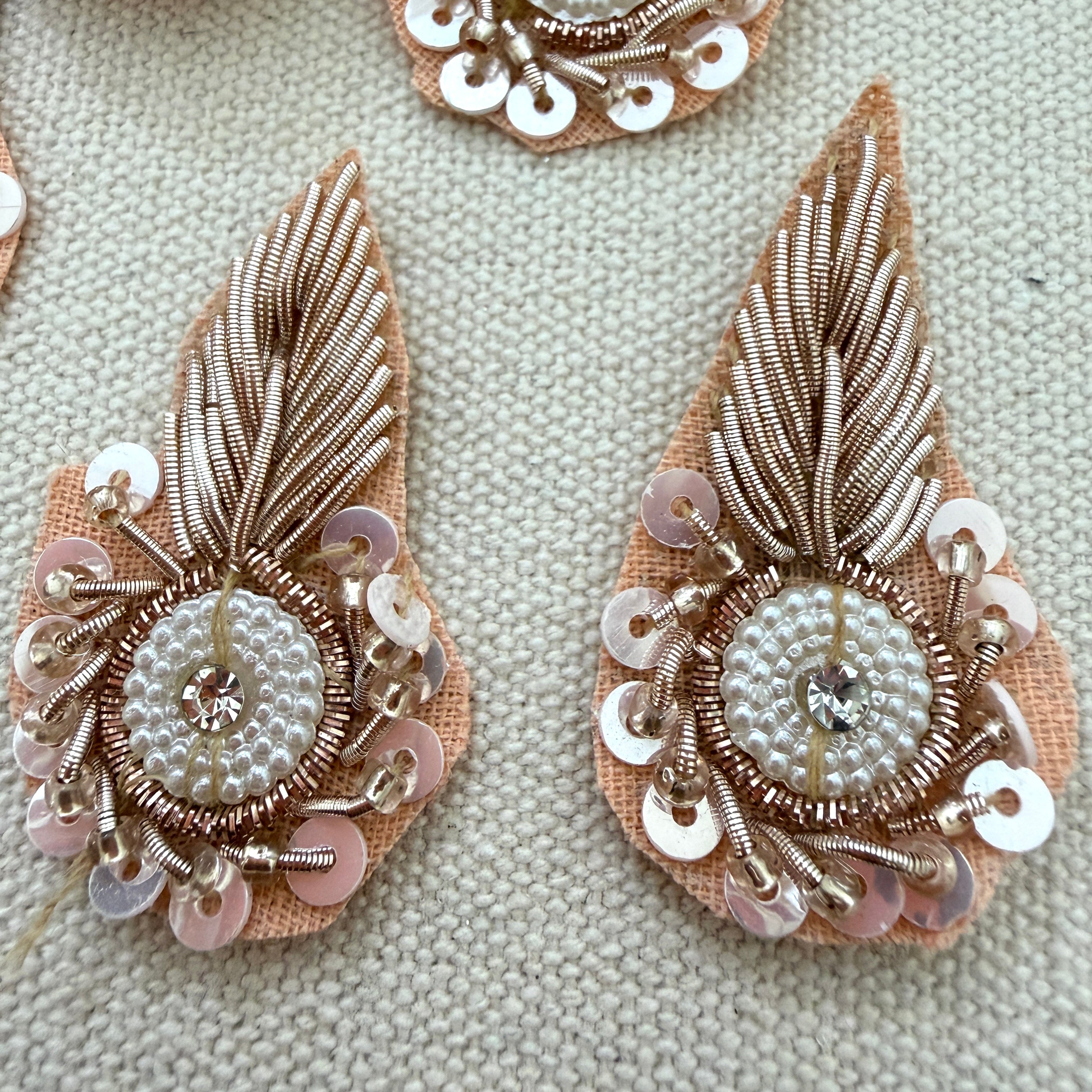 Decorative brooches with intricate designs on a textured surface