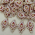Decorative brooch with red, white, and gold colors on a beige background