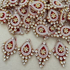 Decorative brooch with red, white, and gold colors on a beige background