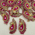 Decorative pink and gold earrings with gemstones on a light background