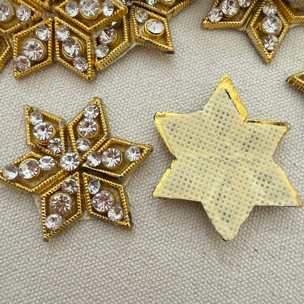 Decorative gold stars with rhinestones on a textured surface