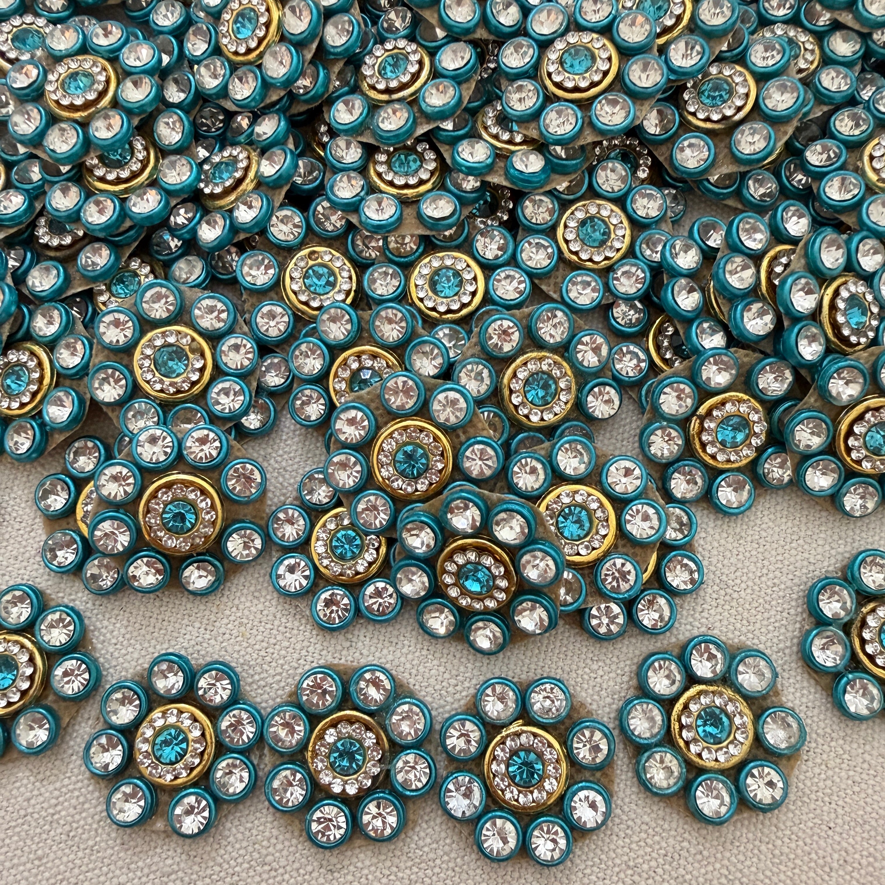 Close-up of decorative buttons with blue and gold colors on a textured surface