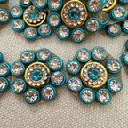 Close-up of decorative buttons with blue and gold centers on a textured surface
