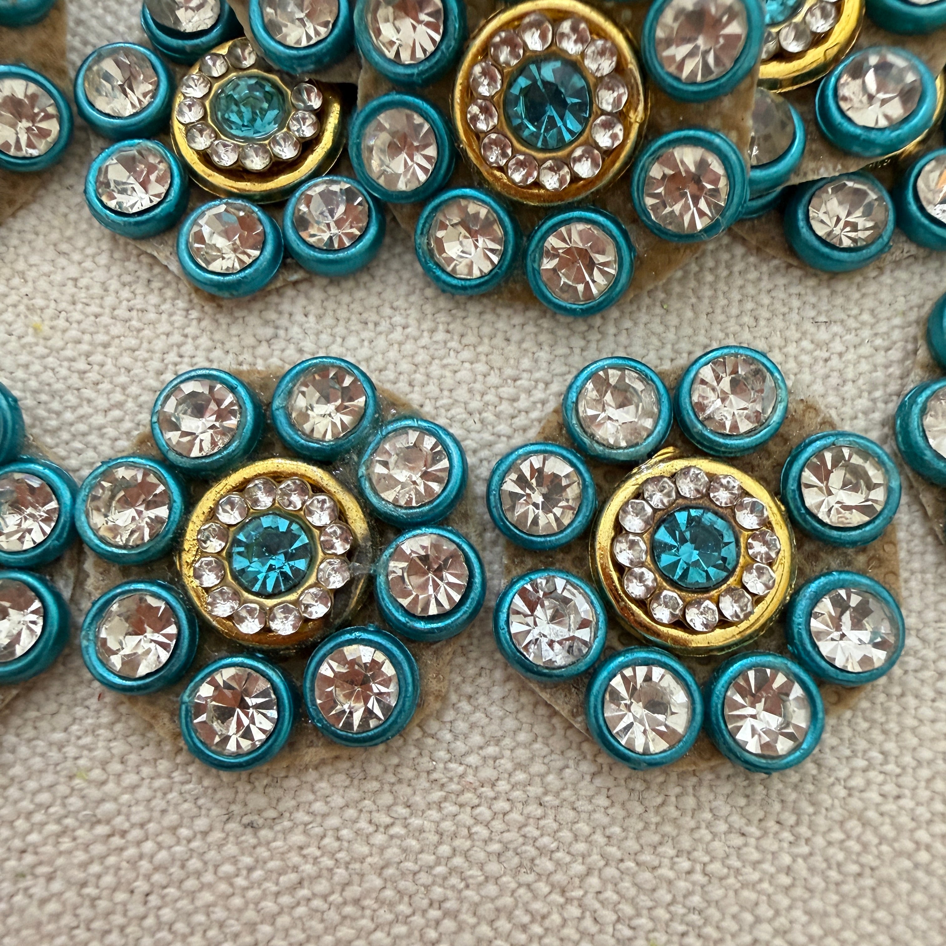 Close-up of decorative buttons with blue and gold centers on a textured surface