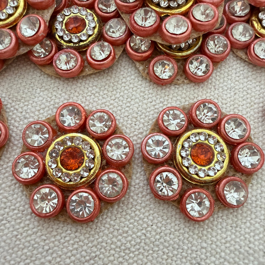 Close-up of decorative buttons with gemstones on a textured surface