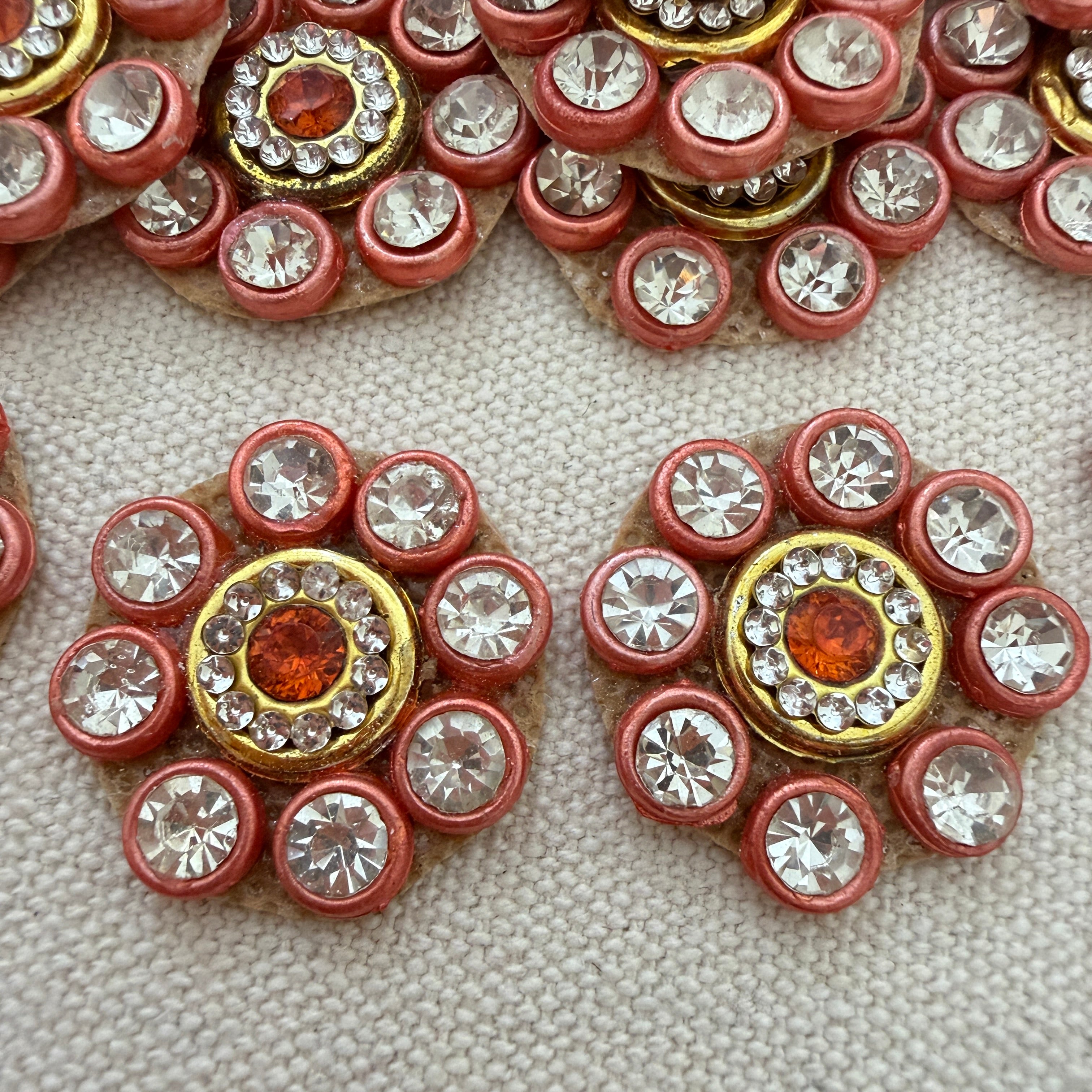 Close-up of decorative buttons with gemstones on a textured surface