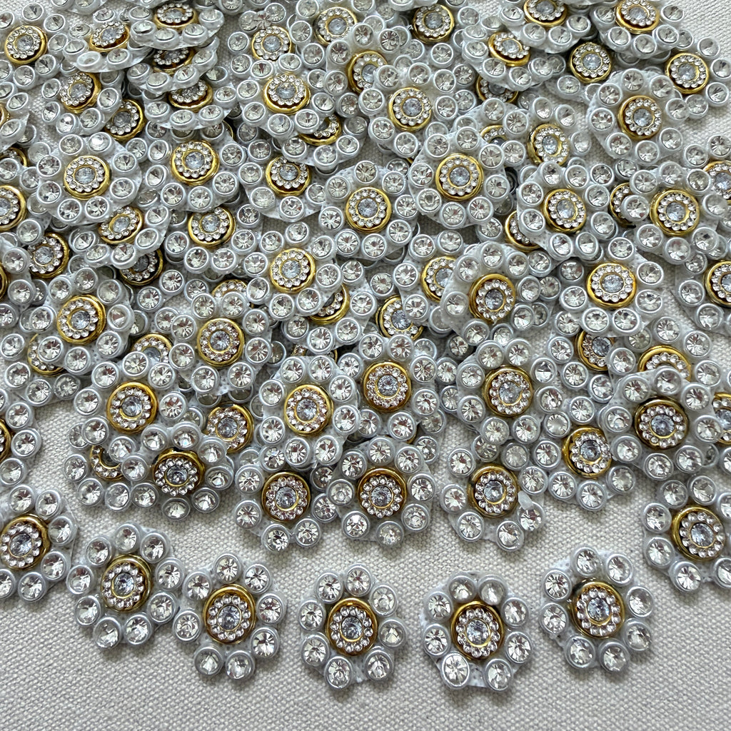 Close-up of decorative buttons with gemstones on a textured fabric background