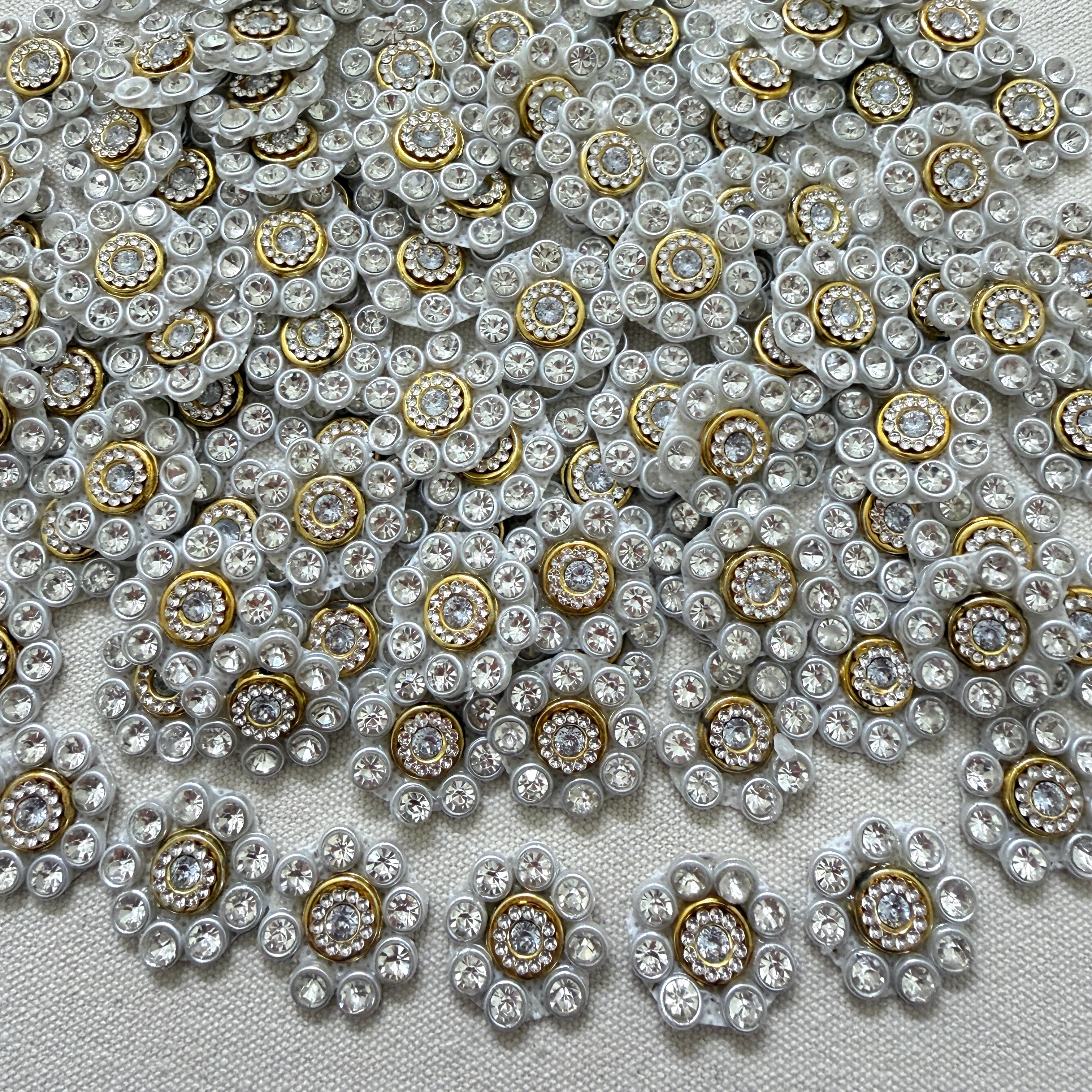 Close-up of decorative buttons with gemstones on a textured fabric background