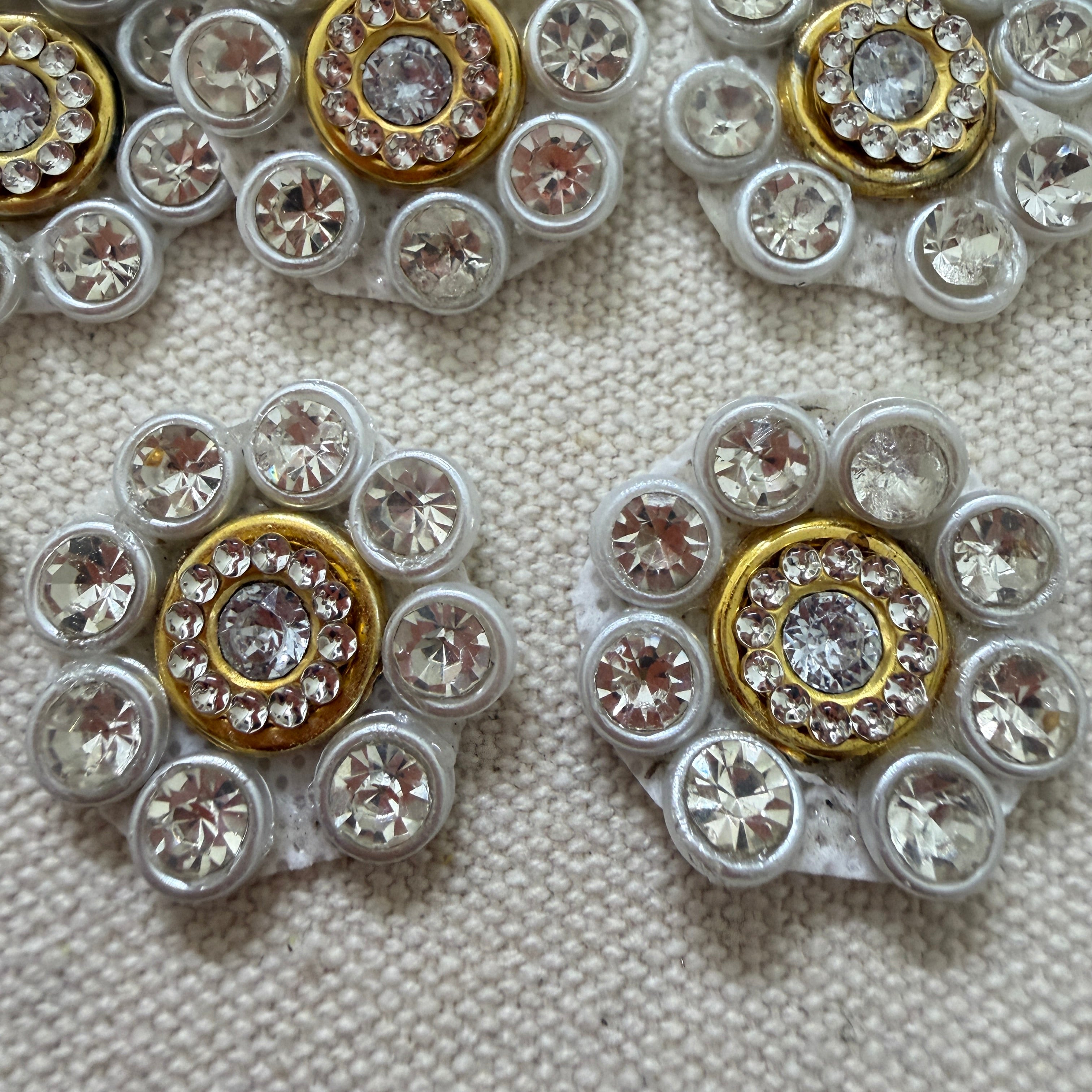 Close-up of decorative buttons with gemstone-like embellishments on a textured surface.