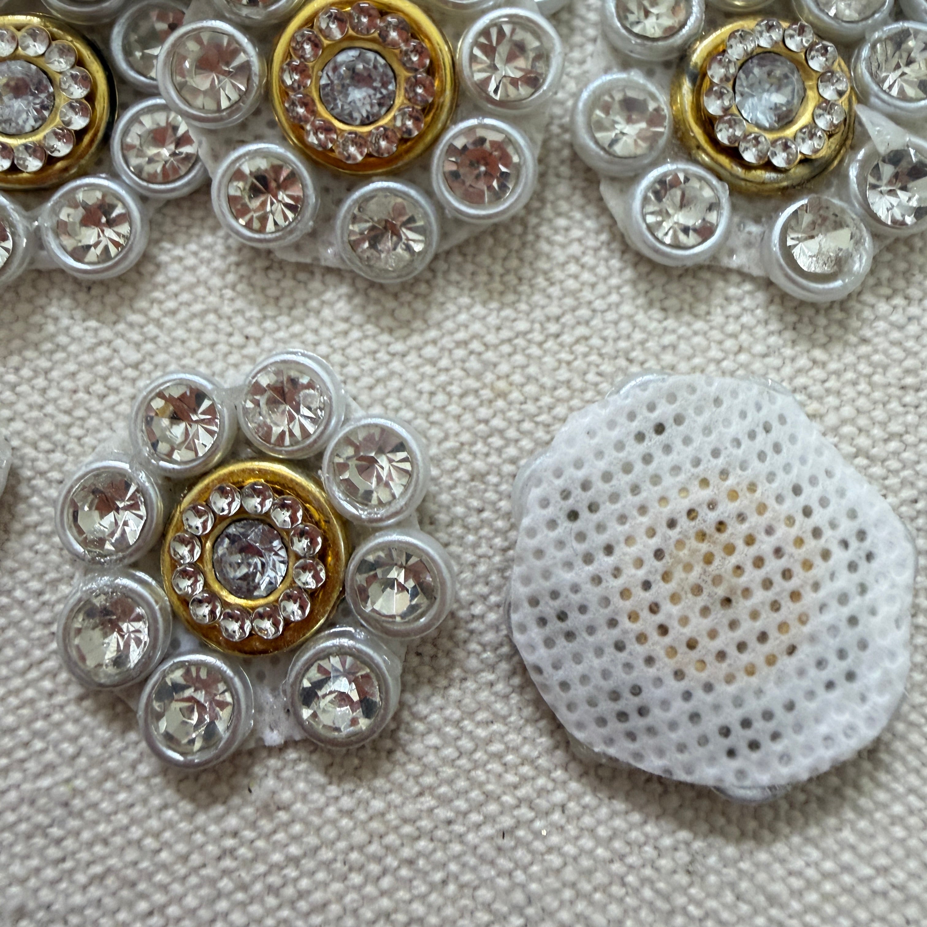 Decorative buttons with gemstone-like embellishments on a textured surface