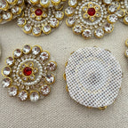 Decorative buttons with gemstones and pearls on a beige background