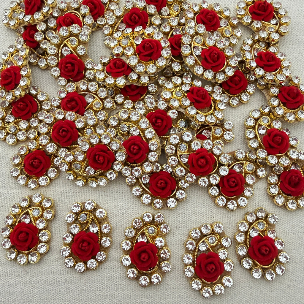 Decorative elements with red roses and gold and silver embellishments on a light background