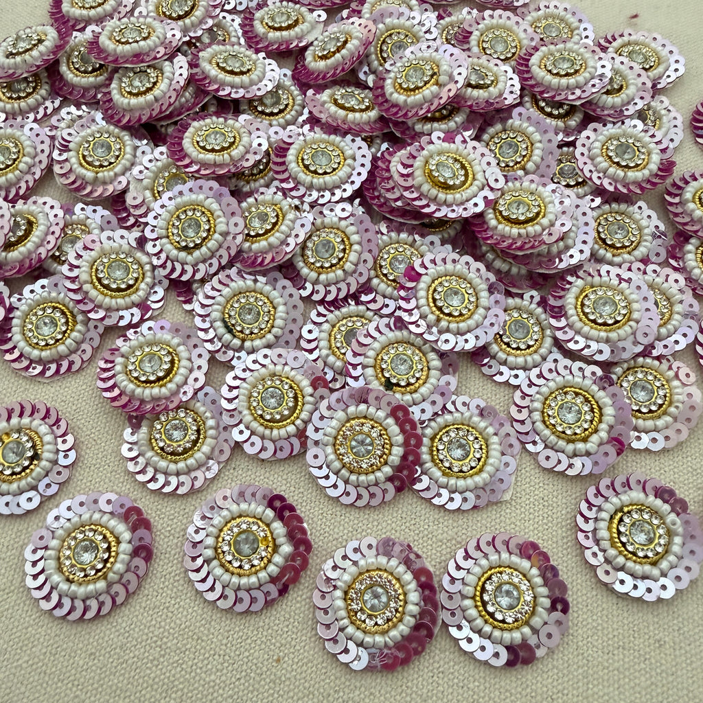 Sequined embellishments with pink, gold, and white colors on a beige background
