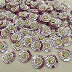 Sequined embellishments with pink, gold, and white colors on a beige background
